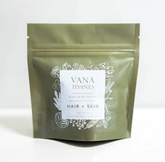 A green bag with white text designed to increase synthesis of collagen for Hair + Skin Fine Plant & Mushroom Powder 2 oz. by Faire.com.