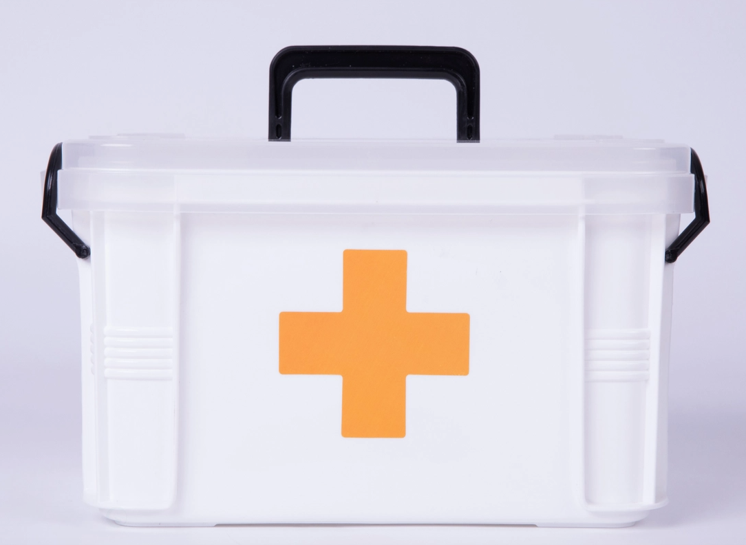 White Faire.com first aid container with orange cross on front.