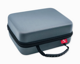 The Faire.com Medication Storage Hard Case in Slate, featuring a durable gray hard-shell exterior with a black zipper, black handle, and a small red tag near the zipper, is designed as a portable medication organizer or storage solution and is shown against a white background.