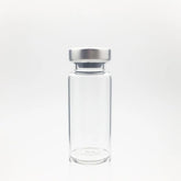 A Sterile Empty Vial 2cc (2ml) by ALK, made of clear Type I borosilicate glass with a silver metal cap, is shown upright against a plain white background. Price per vial increases to $1.54 from $1.03 on 6/6/25.